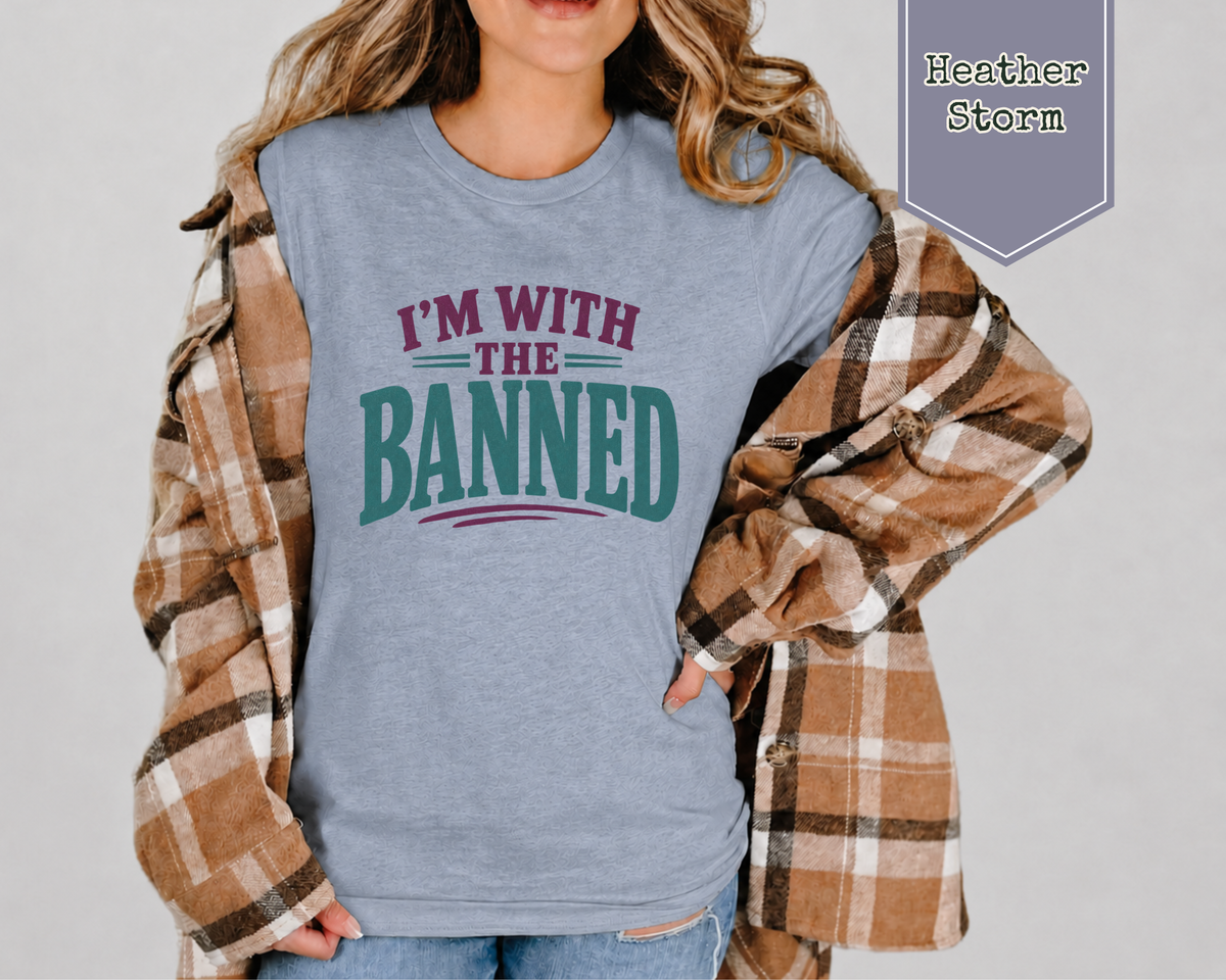 A woman wearing a t-shirt and a flannel long sleeve shirt. The t-shirt with purple and green phrase of I'm With The Banned.