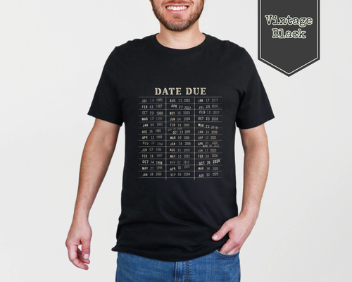 A man wearing a vintage black t-shirt with a beige 'Date Due' calendar grid print, shown against a light gray background with a 'Vintage Black' label overlay.