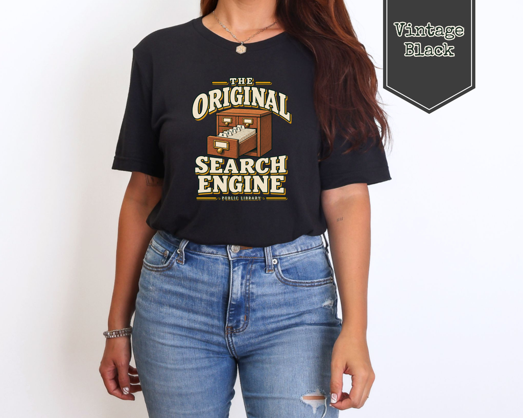 A woman wearing a black graphic t-shirt with a vintage-style library search engine illustration and text, paired with blue jeans. A badge in the top right corner reads 'Vintage Black'.