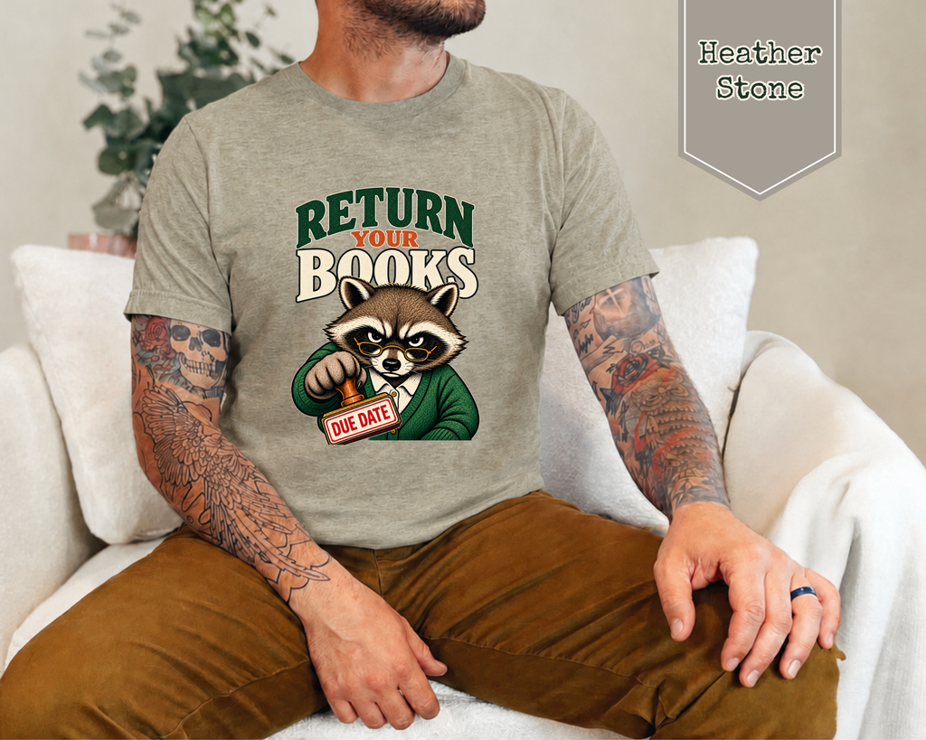 A man wearing a heather stone graphic t-shirt with a cartoon raccoon holding a 'DUE DATE' sign. The man is sitting on a white couch, and a badge in the top right corner reads 'Heather Stone'.