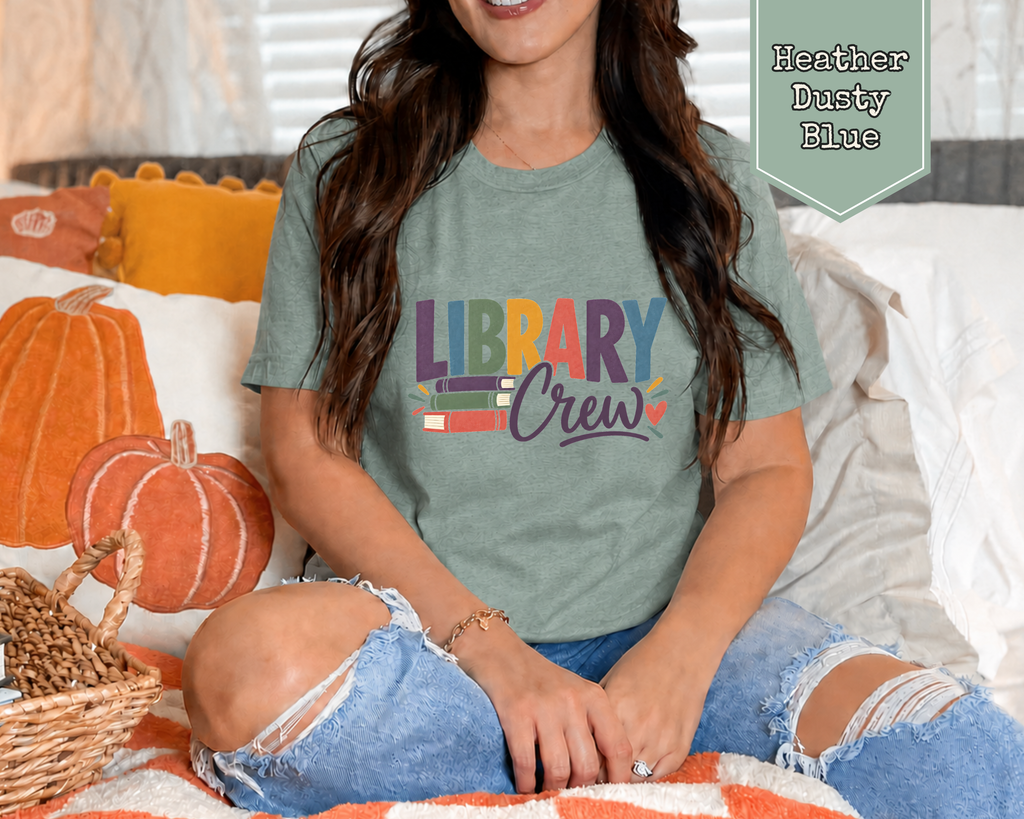 Woman wearing a vintage Heather Mustard Library Crew book lover t-shirt in cozy reading nook.