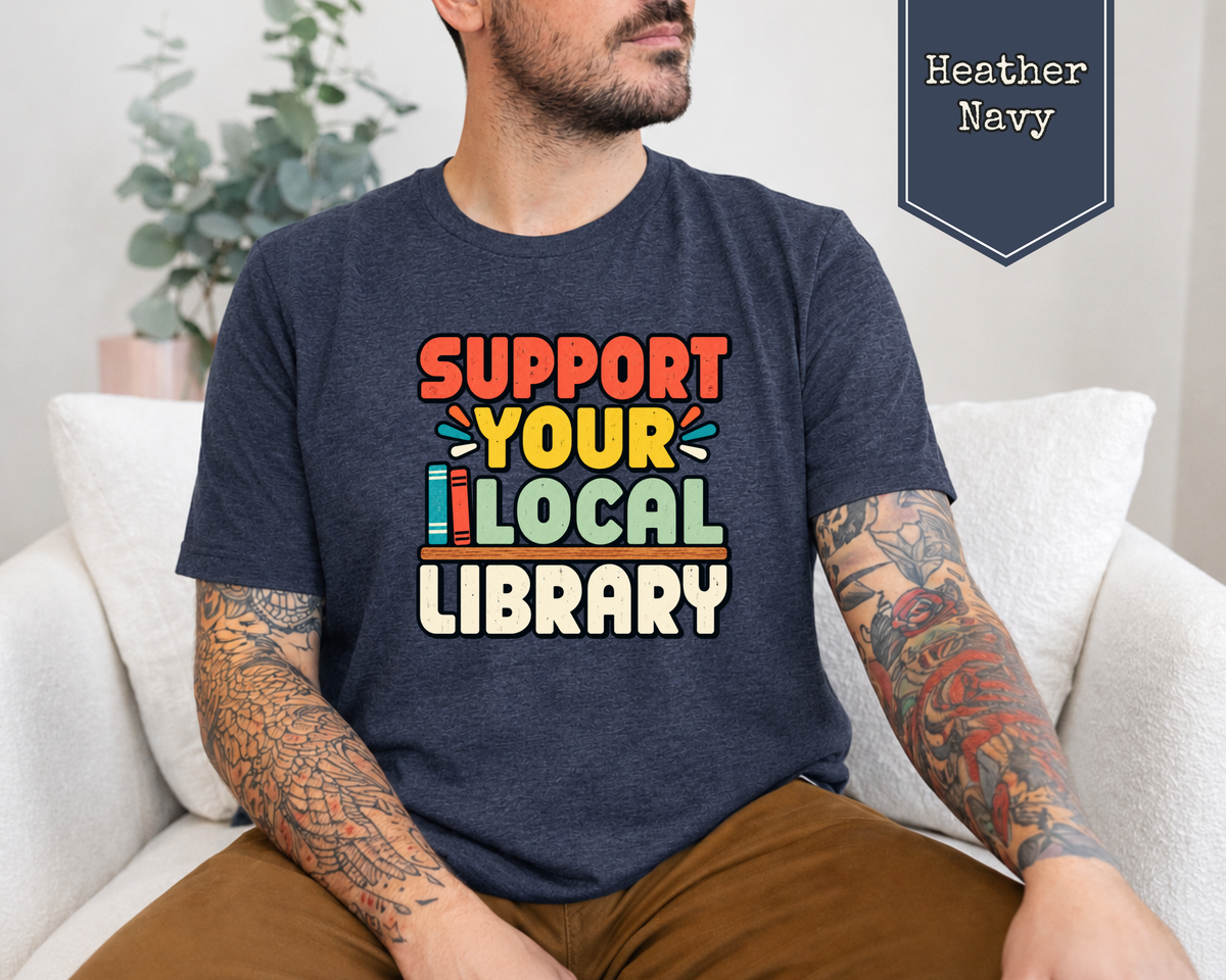 Woman wearing Heather Brown retro Support Your Local Library t-shirt in library setting.