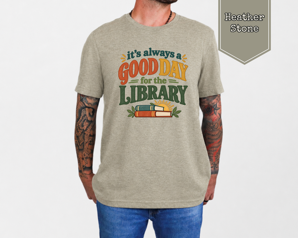 Woman wearing Heather Mustard Good Day for the Library retro librarian graphic t-shirt in cozy reading room.