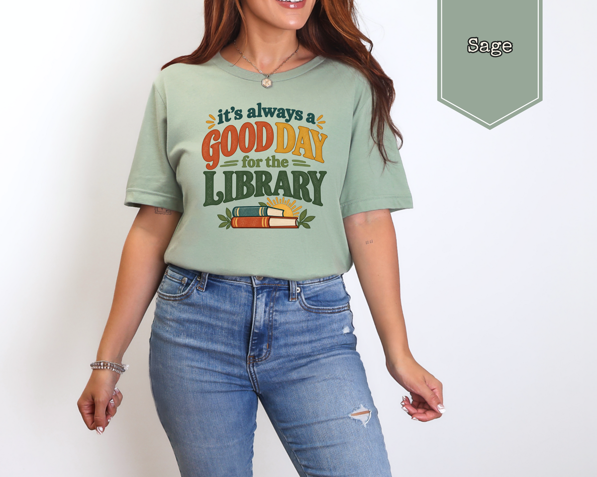 Model wearing Heather Tan Good Day for the Library unisex tee in a library setting.