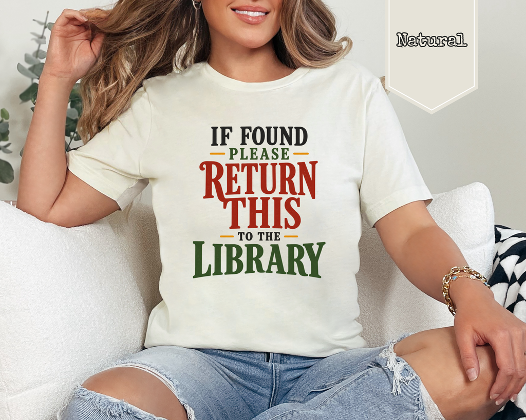 Cream graphic t-shirt reading If Found Please Return This To The Library in vintage red and green lettering.