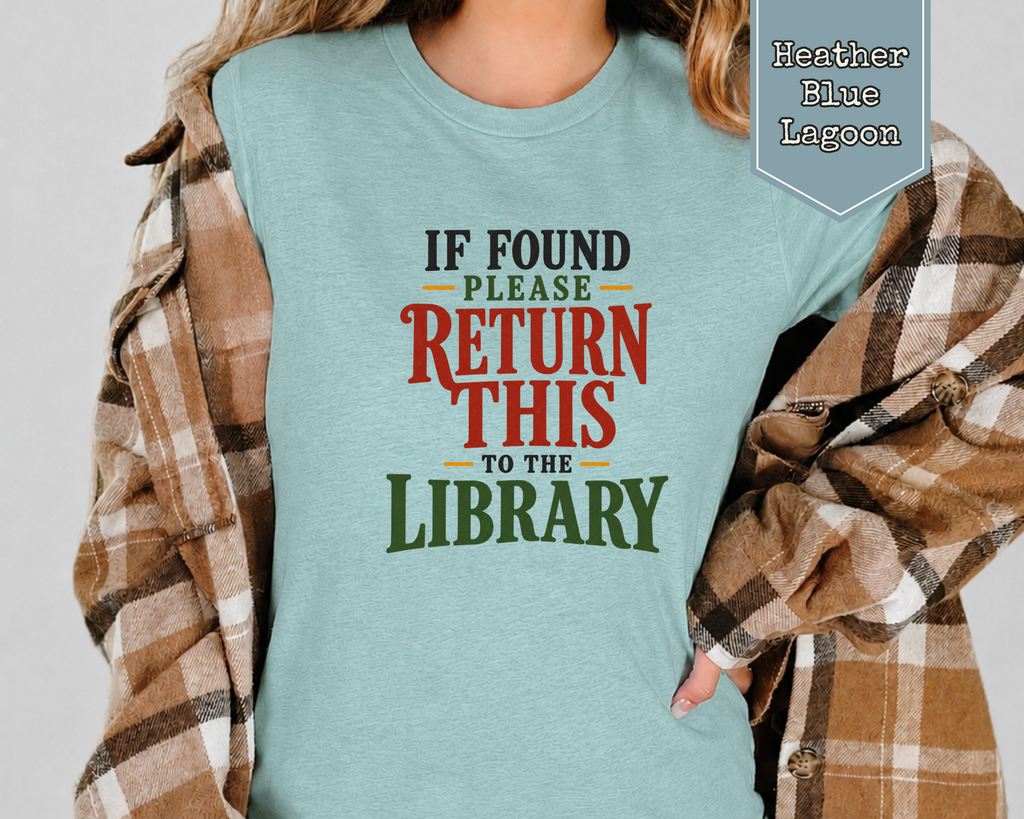 Woman wearing Heather Dust funny librarian reading shirt in cozy nook.