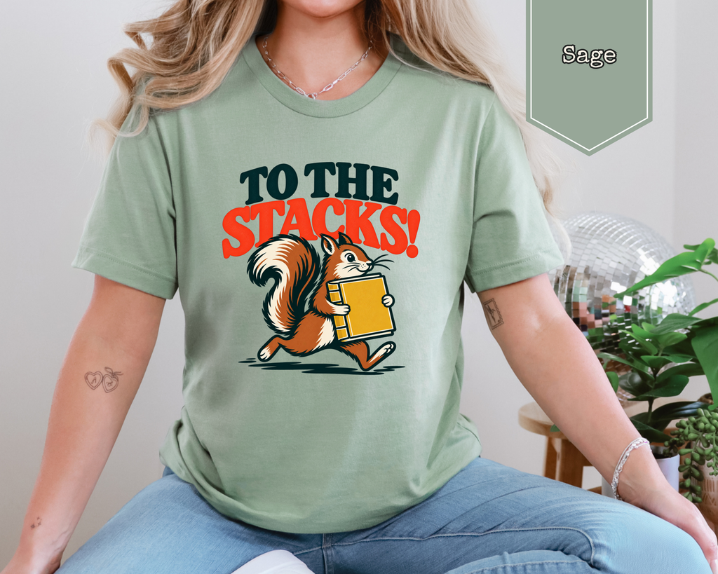 Model wearing Heather Tan To The Stacks unisex library tee in cozy setting.