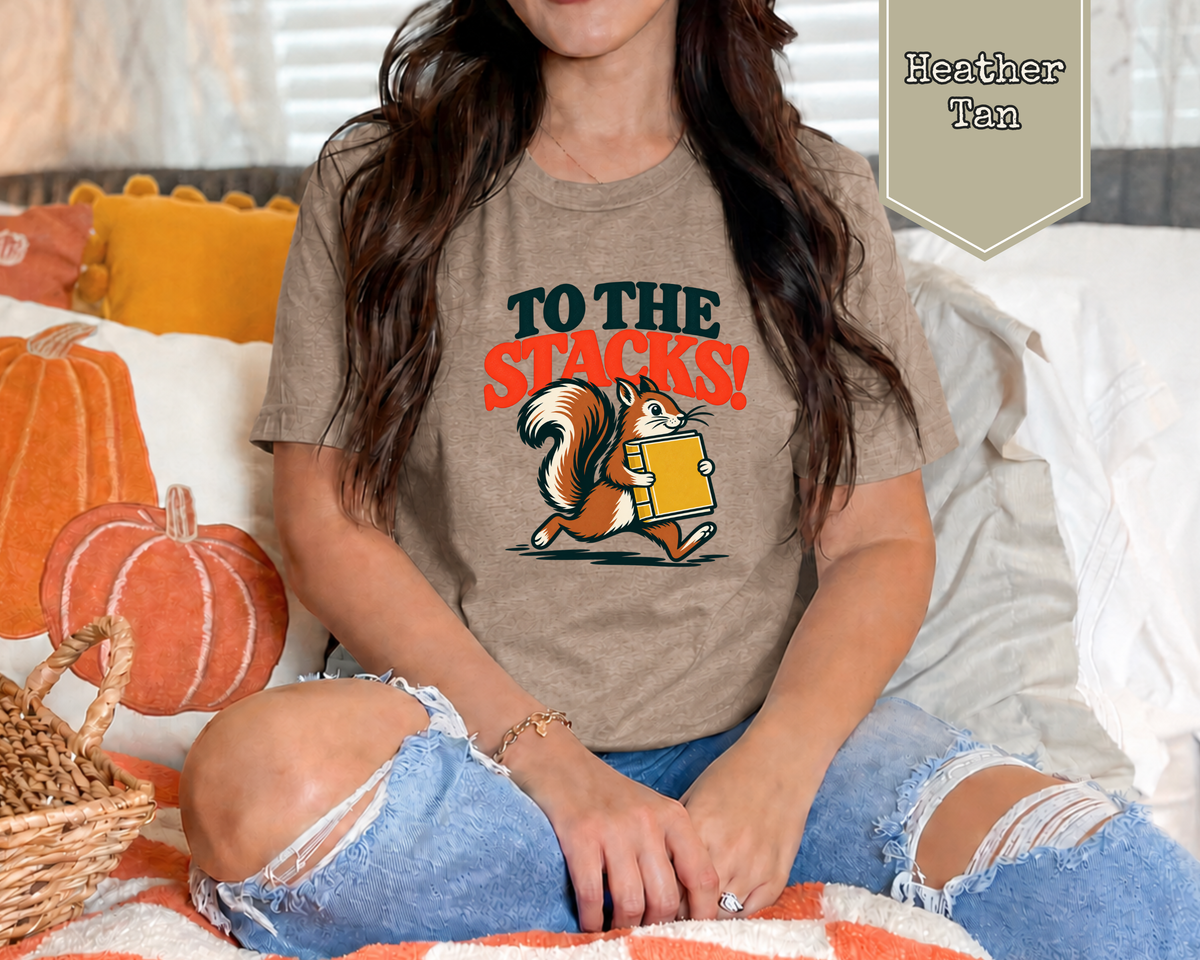 Woman wearing Sage green retro To The Stacks squirrel librarian t-shirt in reading room.