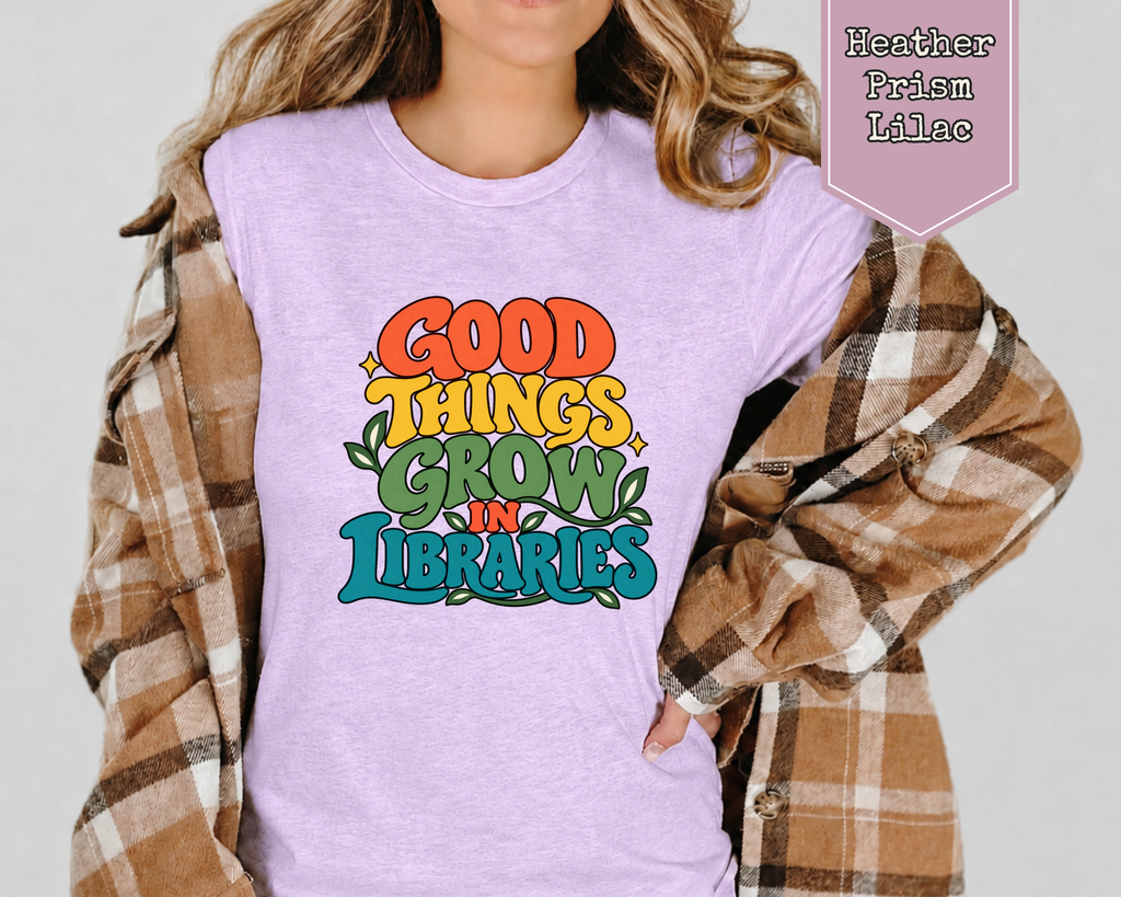 Model wearing Heather True Royal Good Things Grow in Libraries retro book lover shirt.