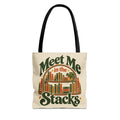 Cream canvas tote bag with vintage green and rust Meet Me in the Stacks typography on front.
